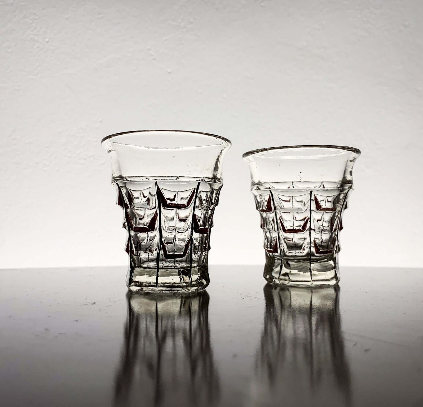 Vintage hand-painted shot glasses by Riihimäen Lasi, 1930s, showcasing pressed geometric design.