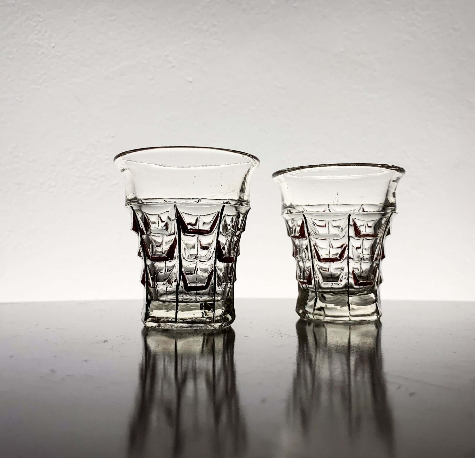 Vintage hand-painted shot glasses by Riihimäen Lasi, 1930s, showcasing pressed geometric design.