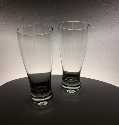 Vintage Saara Hopea beer glasses on a table with soft backlighting, showcasing their elegant design.