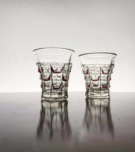 Vintage hand-painted shot glasses by Riihimäen Lasi from the 1930s, featuring geometric designs and red decoration.